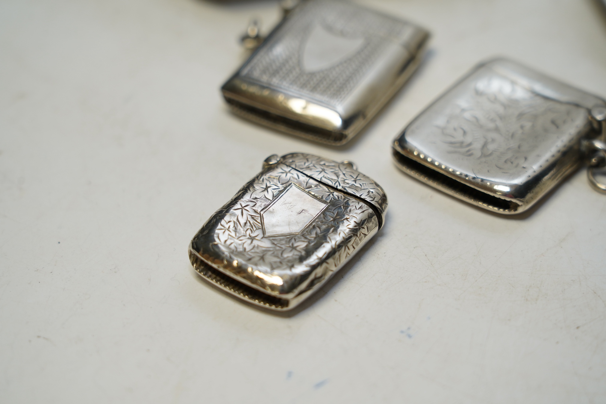 A pair of George V Asprey & Co silver ashtrays, 86mm and three assorted silver vesta cases. Condition - fair to poor.
